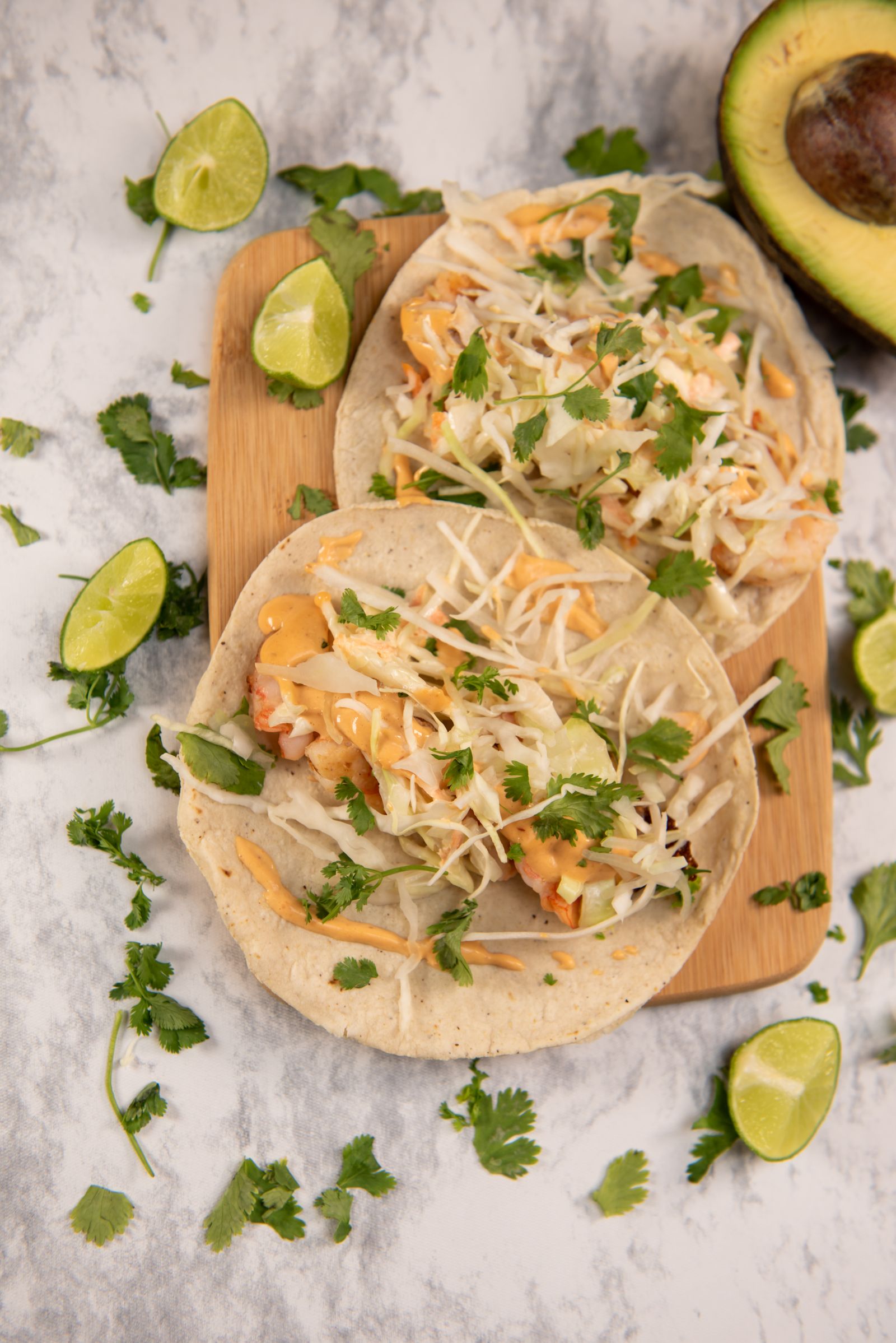 Illustrative Mexican food photograph of tacos with lime, avocado and cilantro
